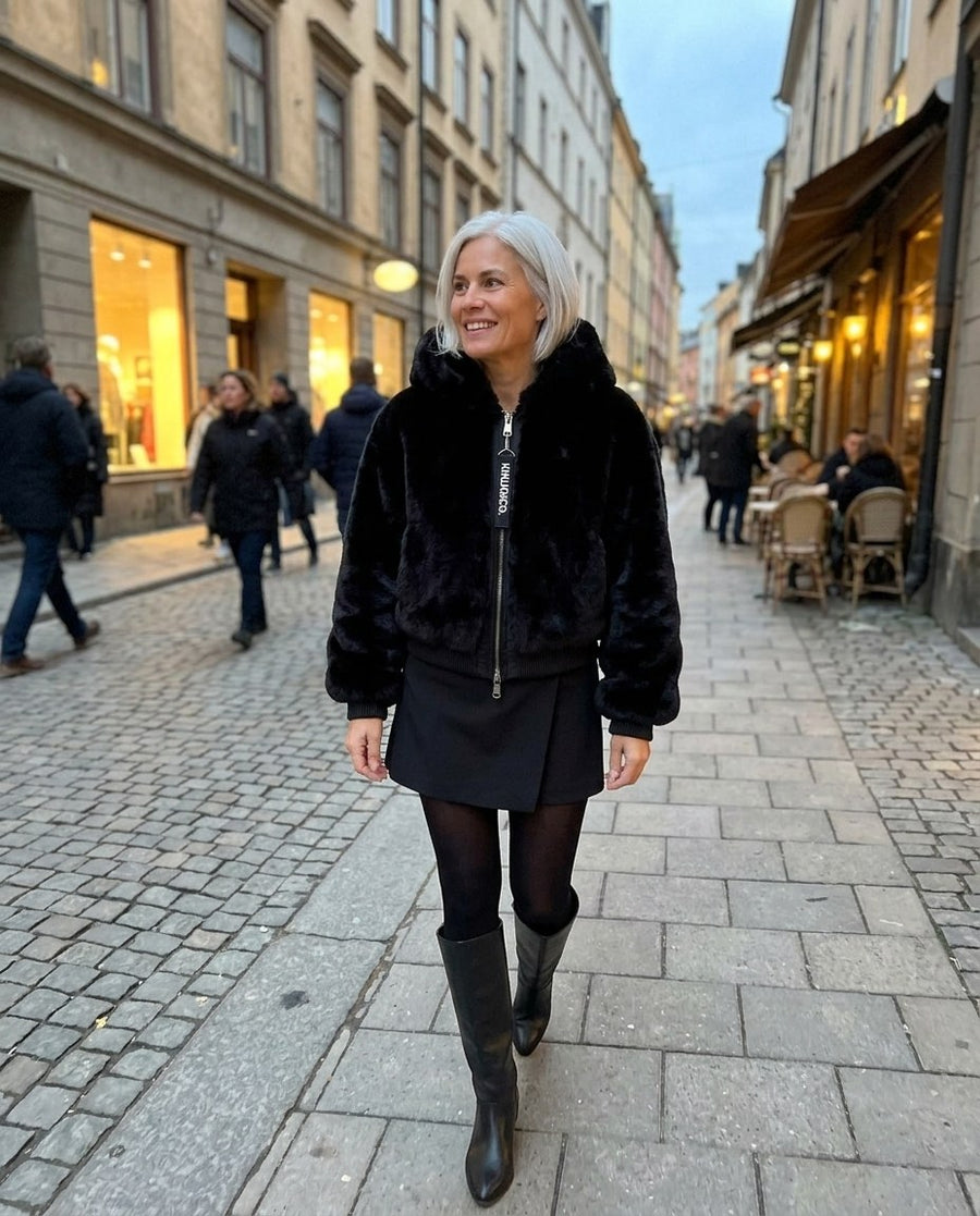 Stina, fuskpälsjacka med huva för dam i svart, stylinginspiration en kväll i stan
