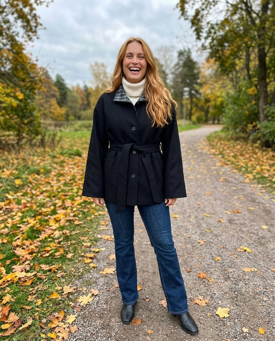 Greta, kappa med skärp och kontrastkrage för dam i svart, stylinginspiration i en höstpark