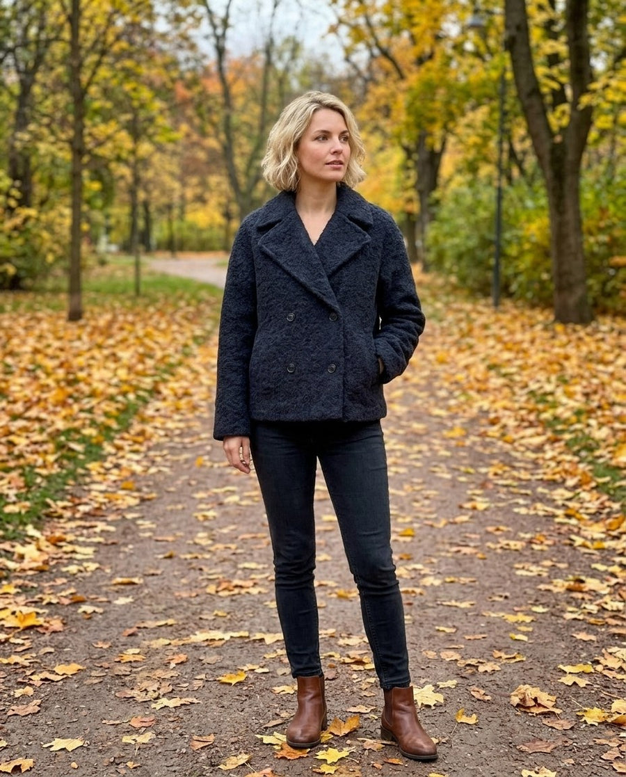 Vilda, kort dubbelknäppt kappa med slagkrage för dam i mörkblå, stylinginspiration i en höstpark