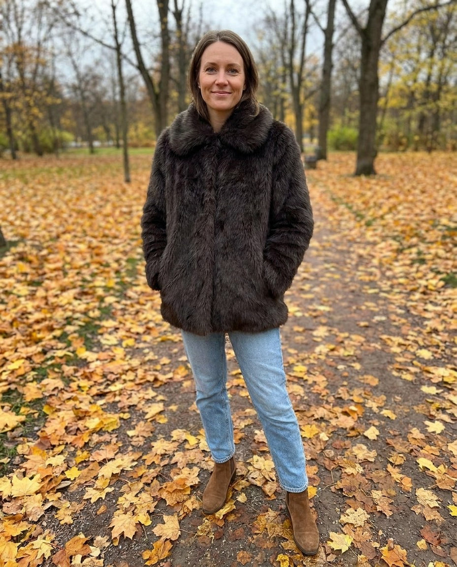 Freja, kort fuskpälsjacka för dam i mörkbrun, stylinginspiration i en höstpark