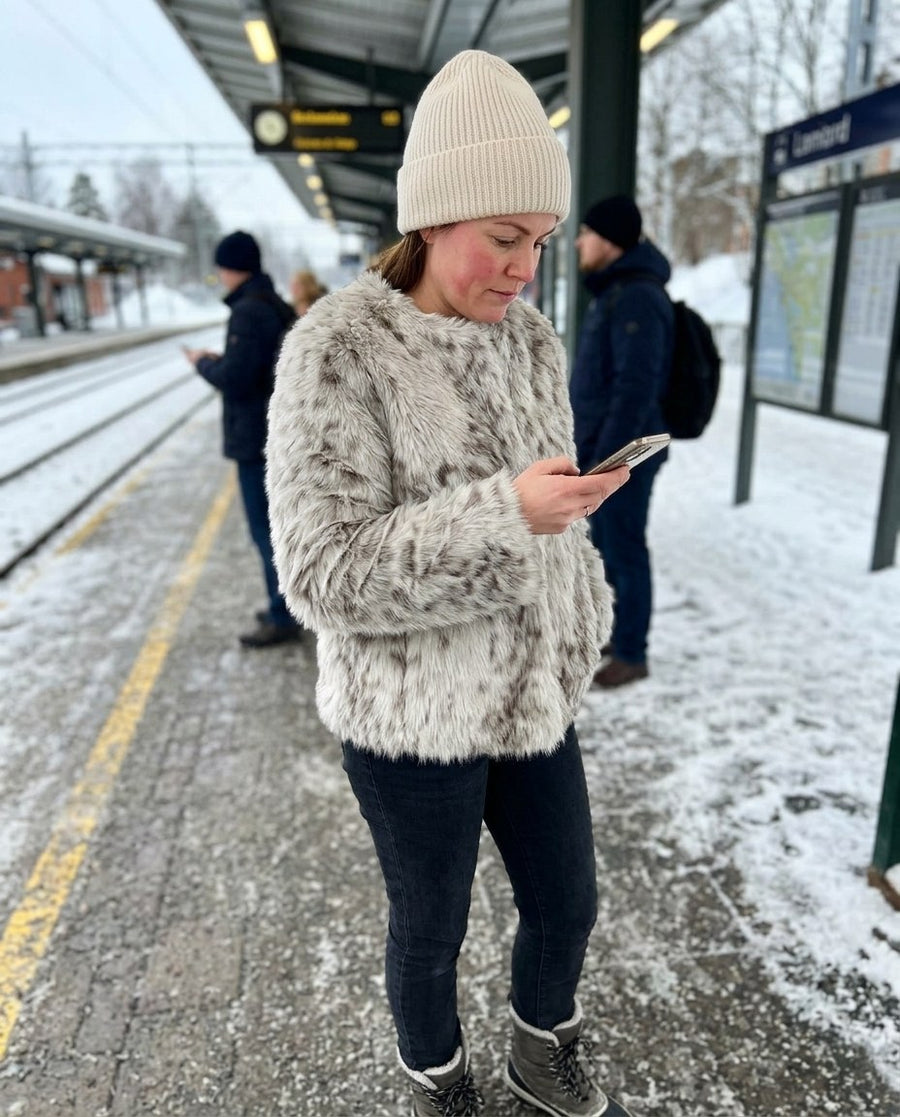 Maja, kort fuskpälsjacka med djurmönster för dam i ljusgrå, stylinginspiration på en perron