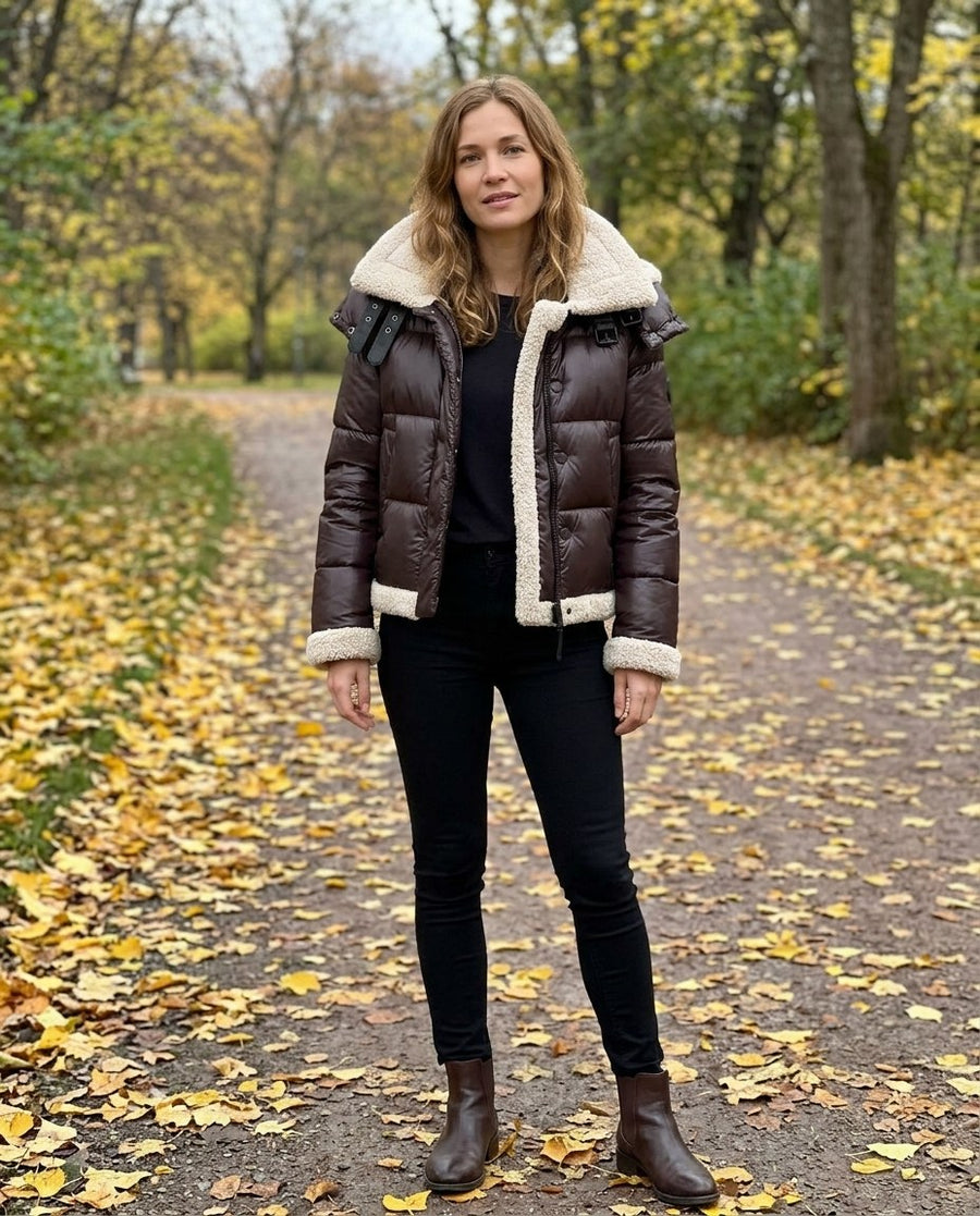 Agnes, kort pufferjacka med fuskpälsdetaljer för dam i mörkbrun, stylinginspiration i en höstpark