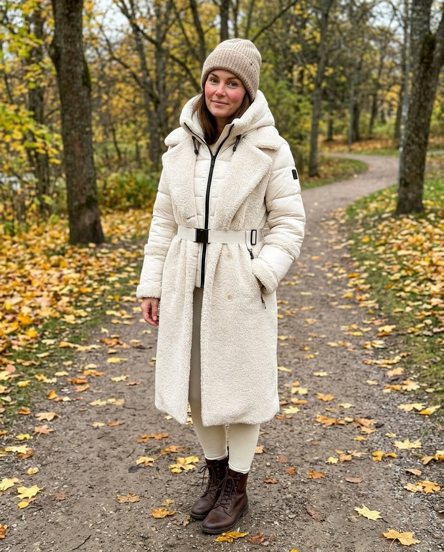 Sigrid, lång 2-i-1-kappa i teddy med avtagbar innerjacka för dam i gräddvit, stylinginspiration i en höstpark