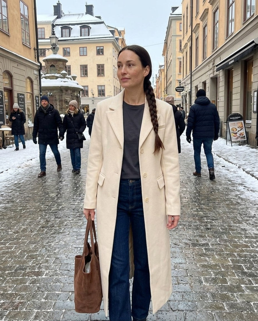 Majken, lång figursydd kappa för dam i ljusbeige, stylinginspiration på en snöig gata