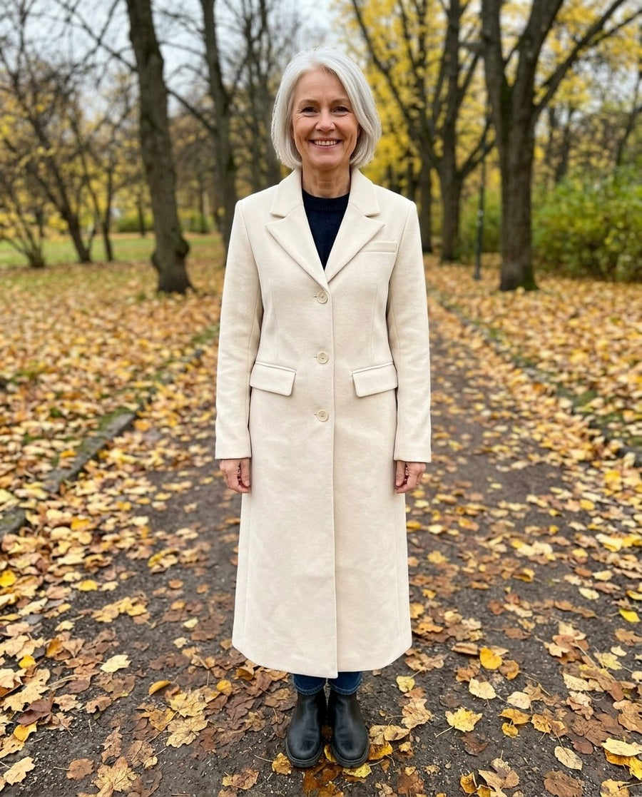Majken, lång figursydd kappa för dam i ljusbeige, stylinginspiration i en höstpark