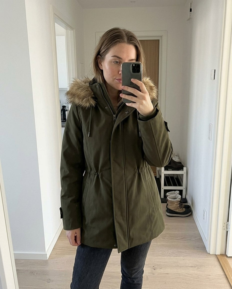 Ellen, parkas med huva för dam i mörkgrön, stylinginspiration spegelbild i hallen