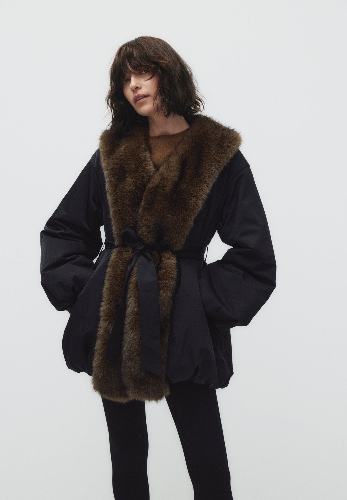 Tilda, svart vadderad jacka med fuskpälskrage och skärp, framifrån