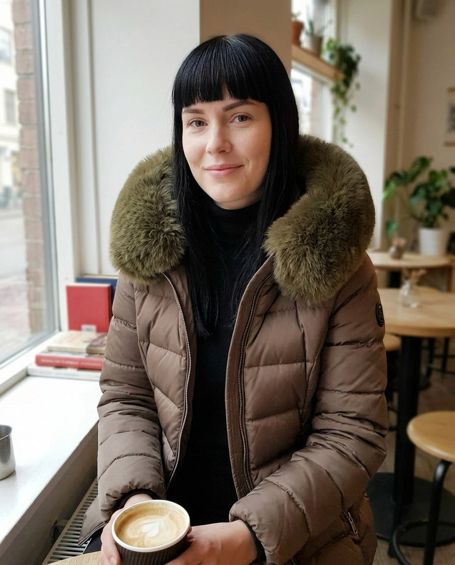 Wilma, vadderad jacka med fuskpälshuva för dam i brun, stylinginspiration på ett kafé