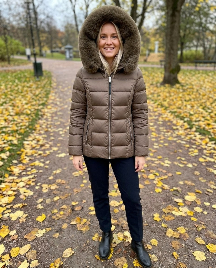 Wilma, vadderad jacka med fuskpälshuva för dam i brun, stylinginspiration i en höstpark